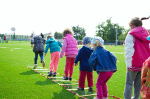 kids running through an agility ladder