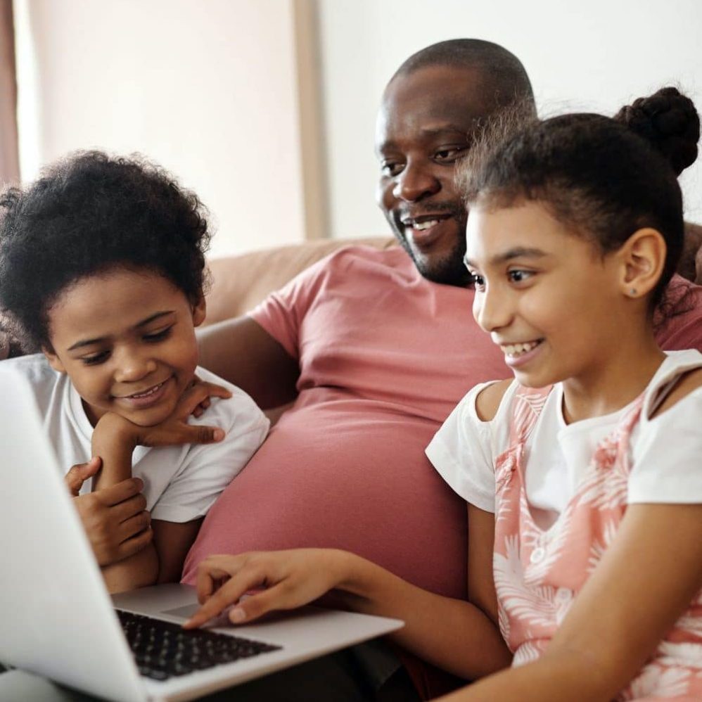 happy-family-sitting-and-looking-at-a-laptop-4260753