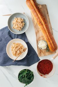 two bowls of ruffle pasta surrounded by ingredients and bread